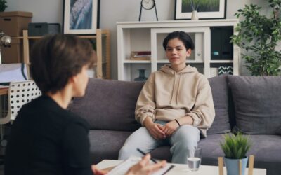 a woman sitting on a couch talking to another woman
